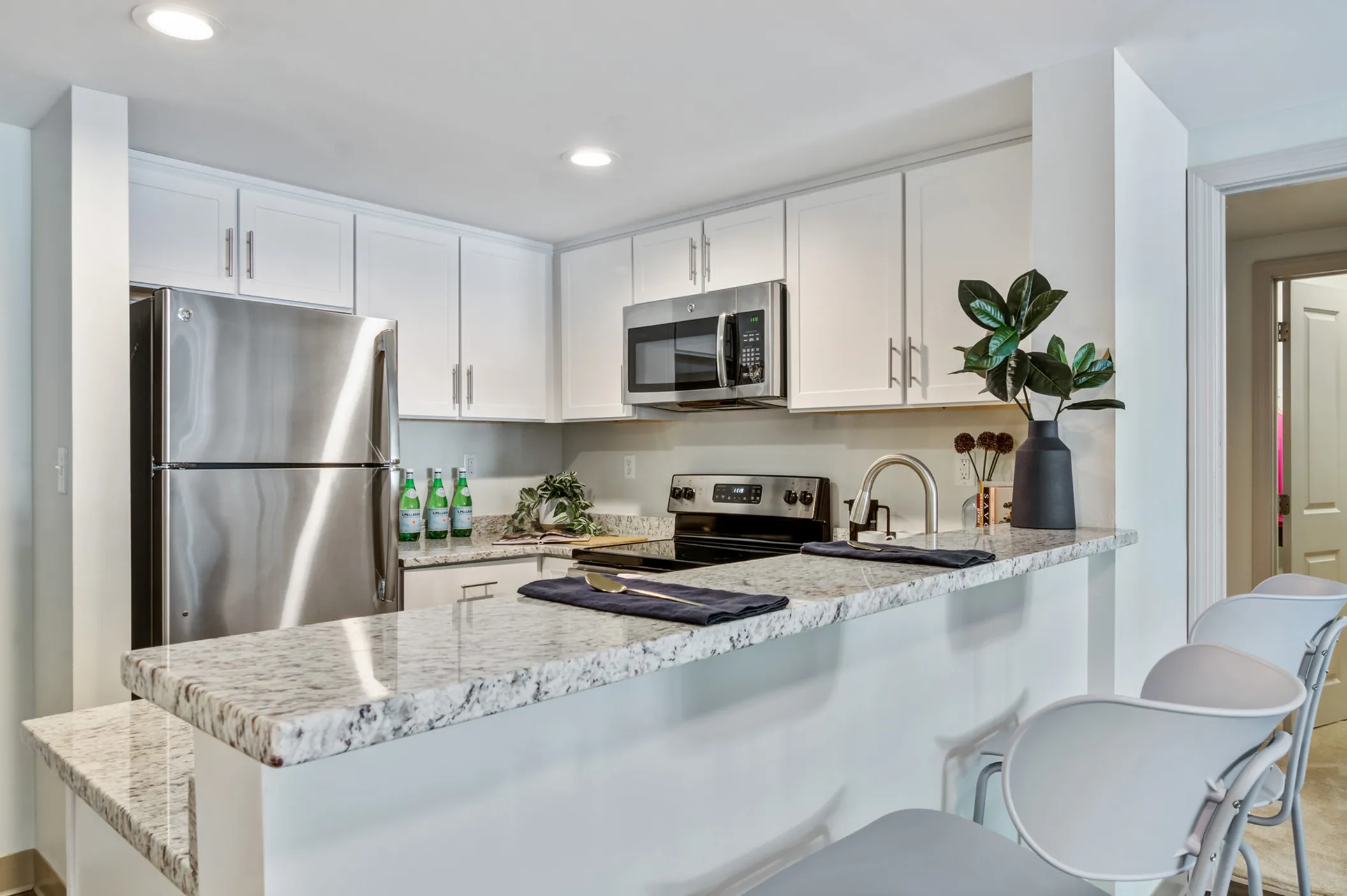 Sleek modern kitchen with stainless steel appliances, elegant countertops, and stylish white cabinetry.