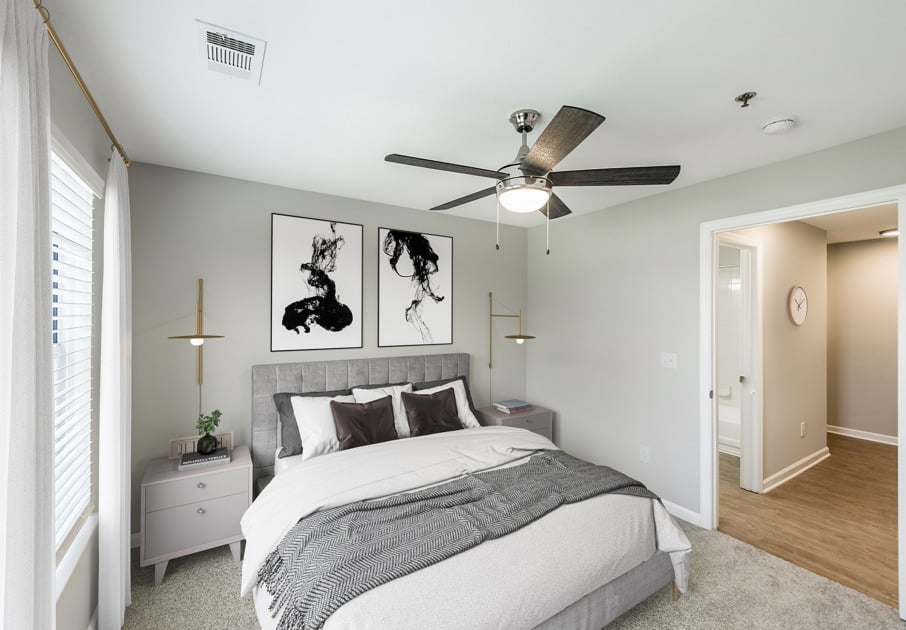 Model bedroom at our apartments for rent in Antioch, TN, featuring carpeted flooring and windows with blinds.