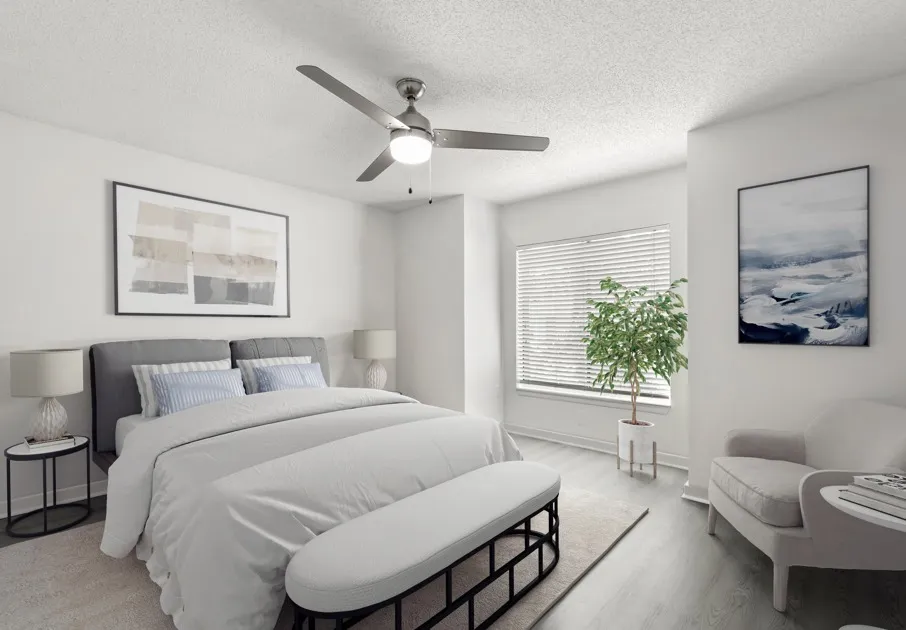 Model bedroom at Avana Lakeview Apartments in Clearwater, FL, featuring wood grain floor paneling and white decor.