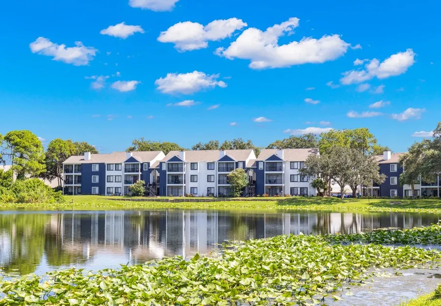 The exterior of the Avana Lakeview Apartments in Clearwater, FL, featuring modern exteriors and a lagoon.