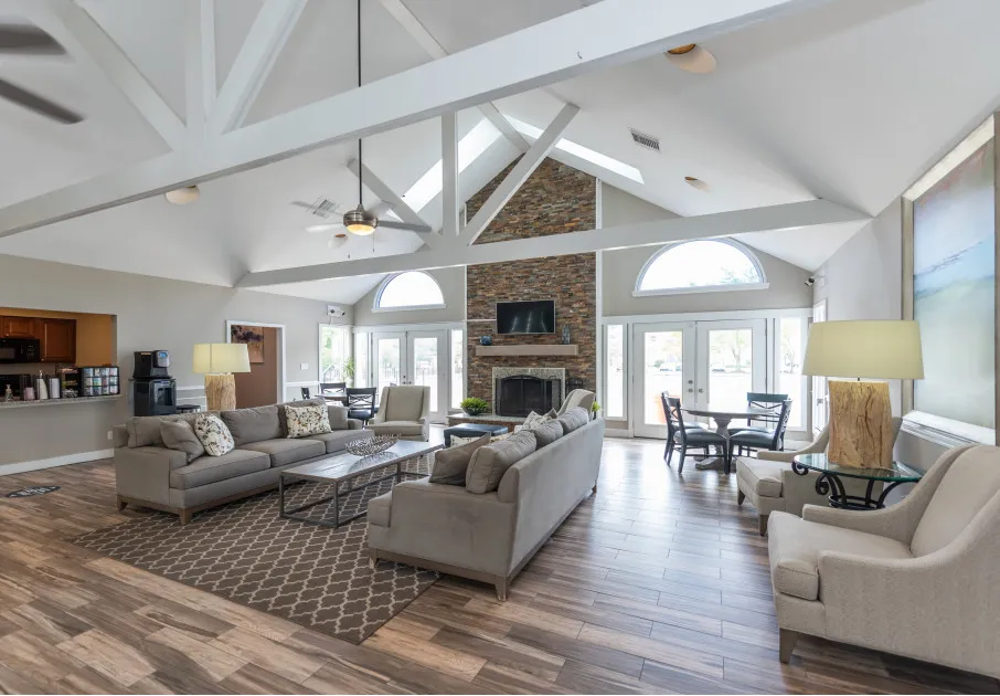 Resident lounge at our apartments for rent in Leesburg, VA, featuring wood grain floor paneling and a fireplace.