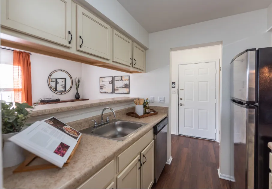 Model kitchen at our apartments for rent in Leesburg, VA, featuring wood grain floor paneling and stainless steel appliances.