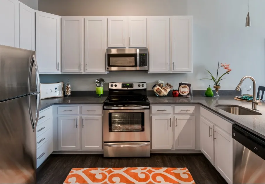 Model kitchen at our apartments for rent in Washington DC, featuring stainless steel appliances and white cabinetry.