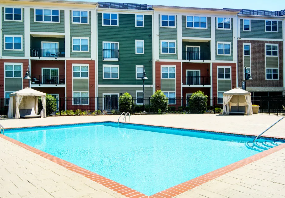 The pool area at our apartments for rent in Washington DC, featuring a covered beach chairs and a view of the apartments.