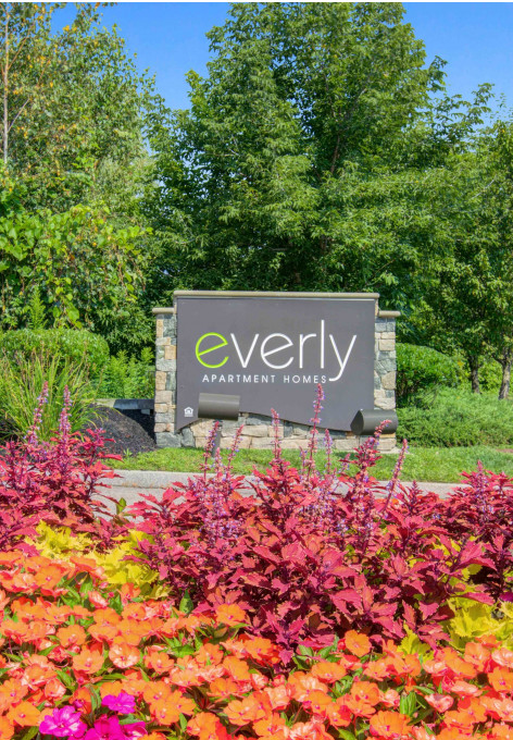 Property sign next to landscaping flower bed