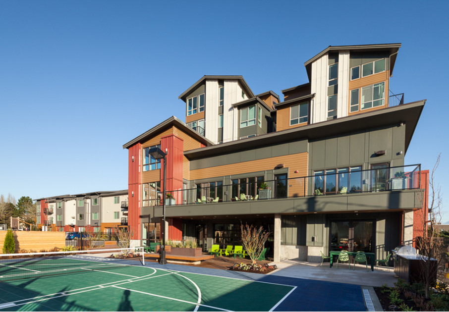 The exterior of our apartments for rent in Kenmore, WA featuring tennis courts, a large deck and outdoor patio.