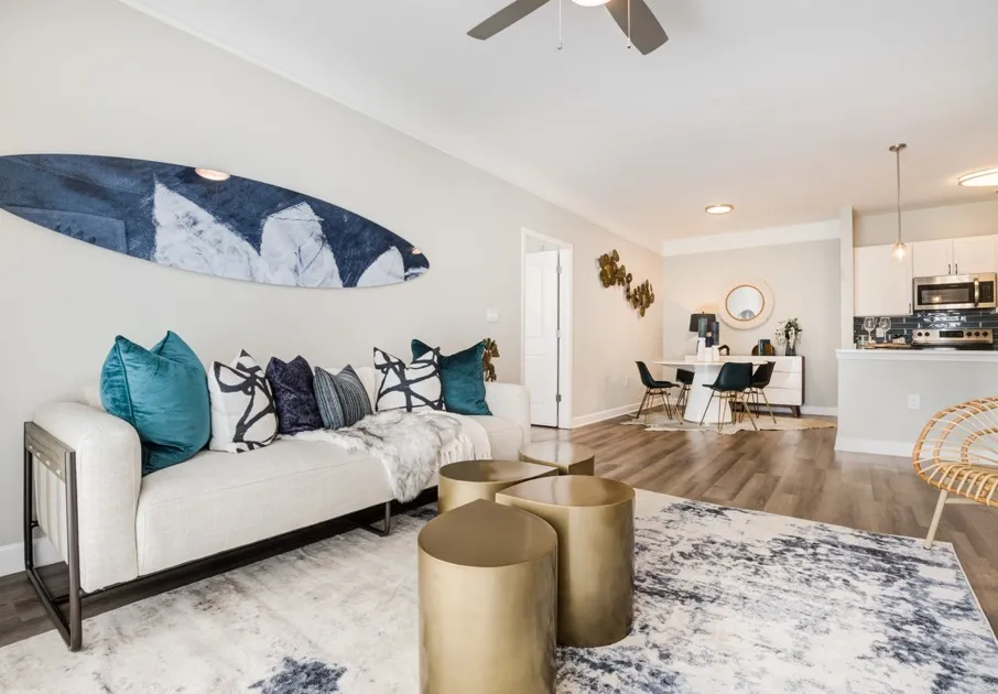 Model living room at our apartments for rent in Mooresville, NC, featuring wood grain floor paneling and a white couch.