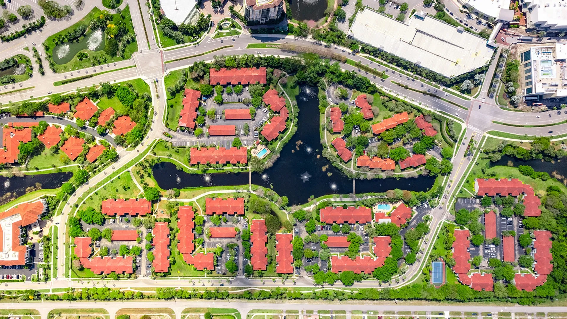 Aerial view of our apartments for rent in West Palm Beach, FL, featuring the neighborhood, ponds, and palm trees.