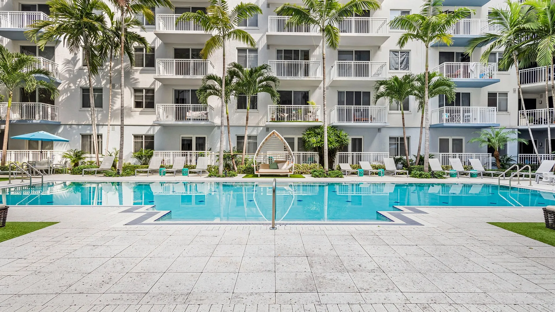 Outdoor swimming pool at our apartments for rent in Boca Raton, FL, featuring lounge chairs and patio seating.