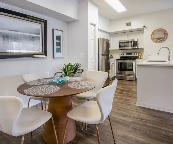 Model dining area at our apartments for rent in West Palm Beach, FL, featuring wood grain flooring and a table.