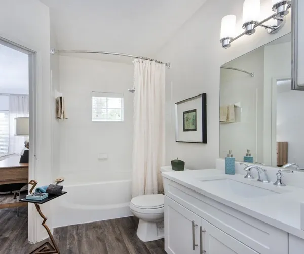 Model bathroom at our luxury apartments for rent in West Palm Beach, FL, featuring a shower and vanity mirror.
