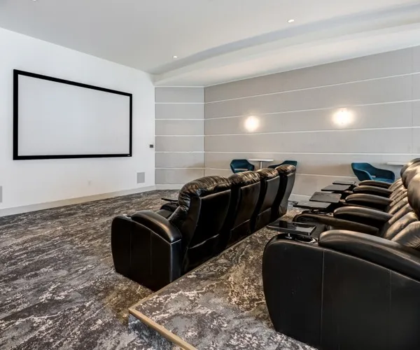 Private movie theater at our Brickell, Miami apartments for rent, featuring leather seats with personal folding tables.