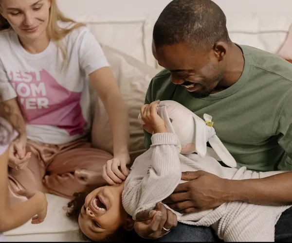 family laughing on the couch with kids