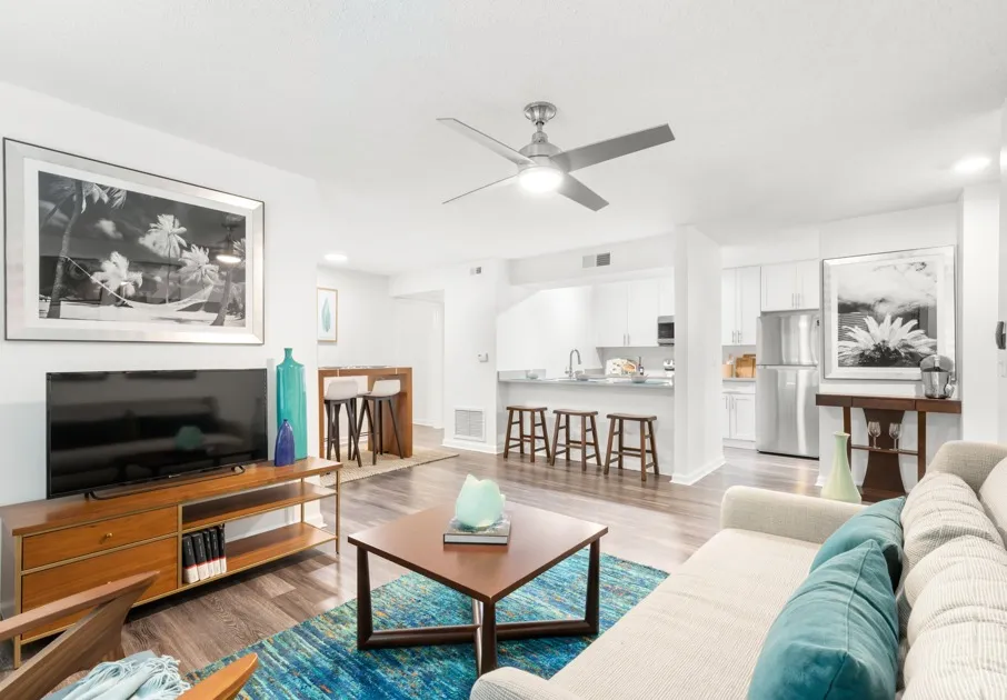 Model living room at our apartments for rent in Clearwater, FL, featuring wood grain floor paneling and a flat screen TV.