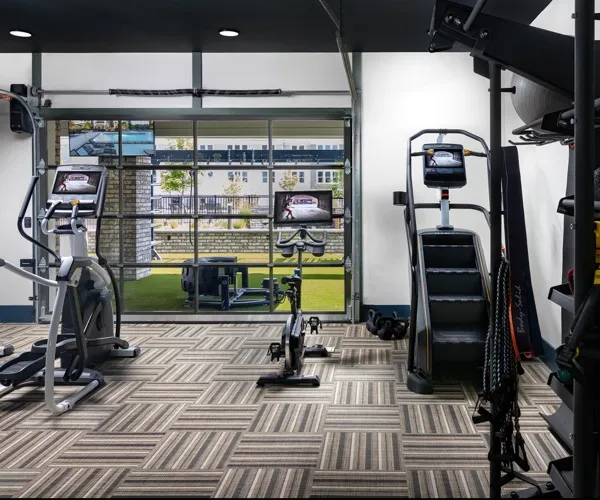 Gym with plenty of cardio and weighlifting equipment, looking out to the Outdoor gym