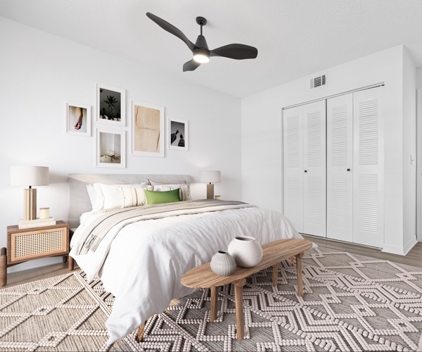 Model bedroom at Avana Palm Beach Gardens in Palm Beach Gardens, FL, featuring wood grain flooring and a closet.