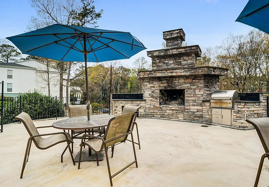 Outdoor fireplace with lounge seating and grill