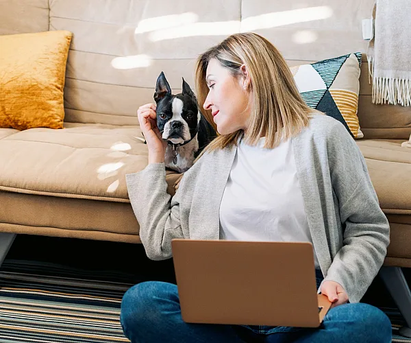 person with dog and computer in lap
