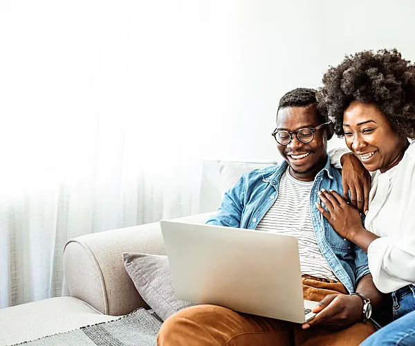 man and woman smiling at a computer