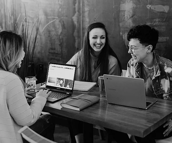 people on computers working and laughing