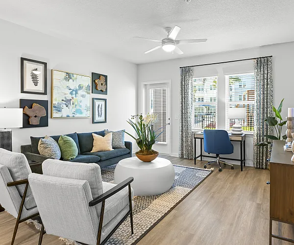 Model living room at Marlowe Jacaranda apartments for rent in Venice, FL, featuring wood grain floor paneling.