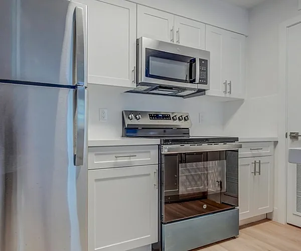 Model kitchen at Avana Coral Springs apartments near Pompano Beach, featuring wood grain flooring and in unit laundry.