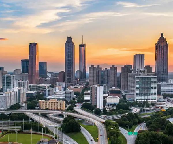 Breathtaking aerial view of a vibrant city skyline at sunset, showcasing stunning architecture and sprawling highways.