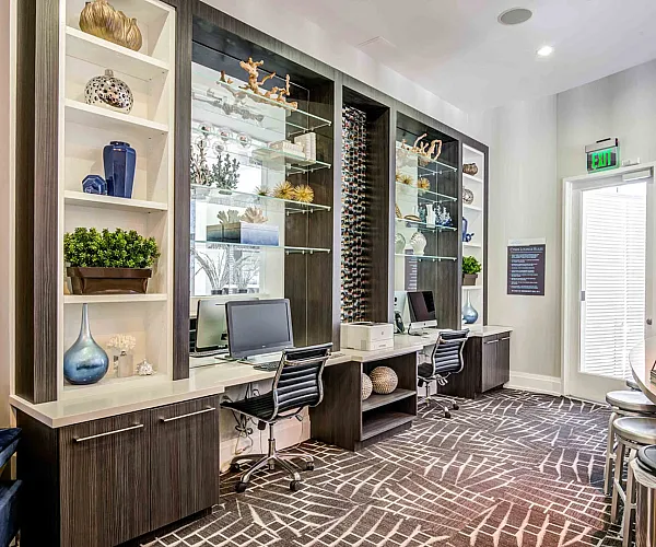 Elegant shared workspace with modern decor, stylish shelving, and comfortable seating in a bright interior.