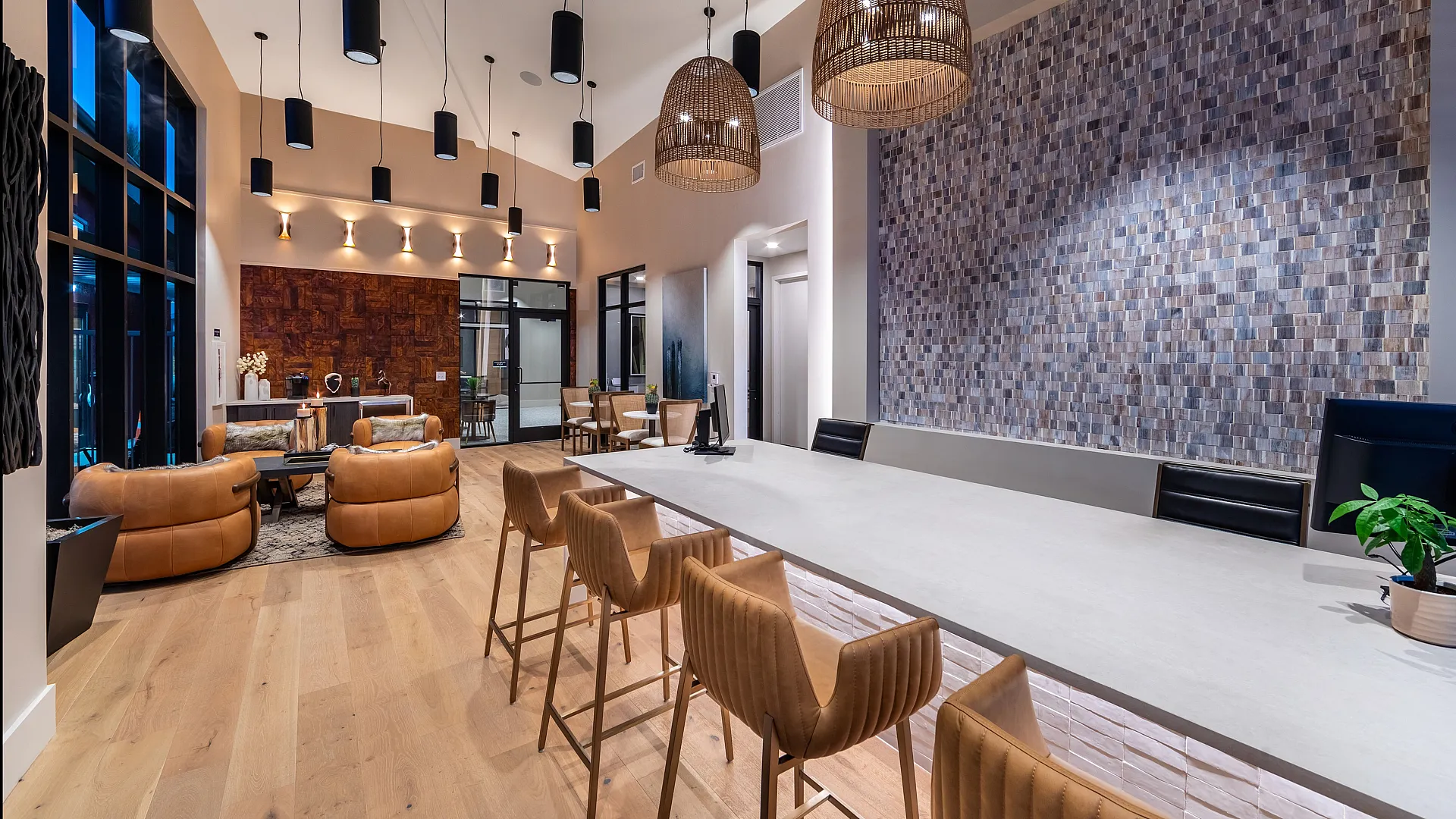 Elegant modern lounge space with stylish pendant lighting, cozy leather seating, and a textured feature wall.