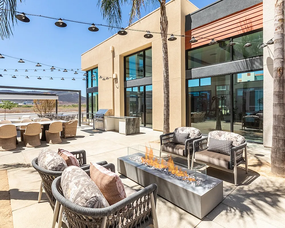 Luxurious outdoor patio with modern seating, cozy fire pit, and stunning landscape views, perfect for entertaining.