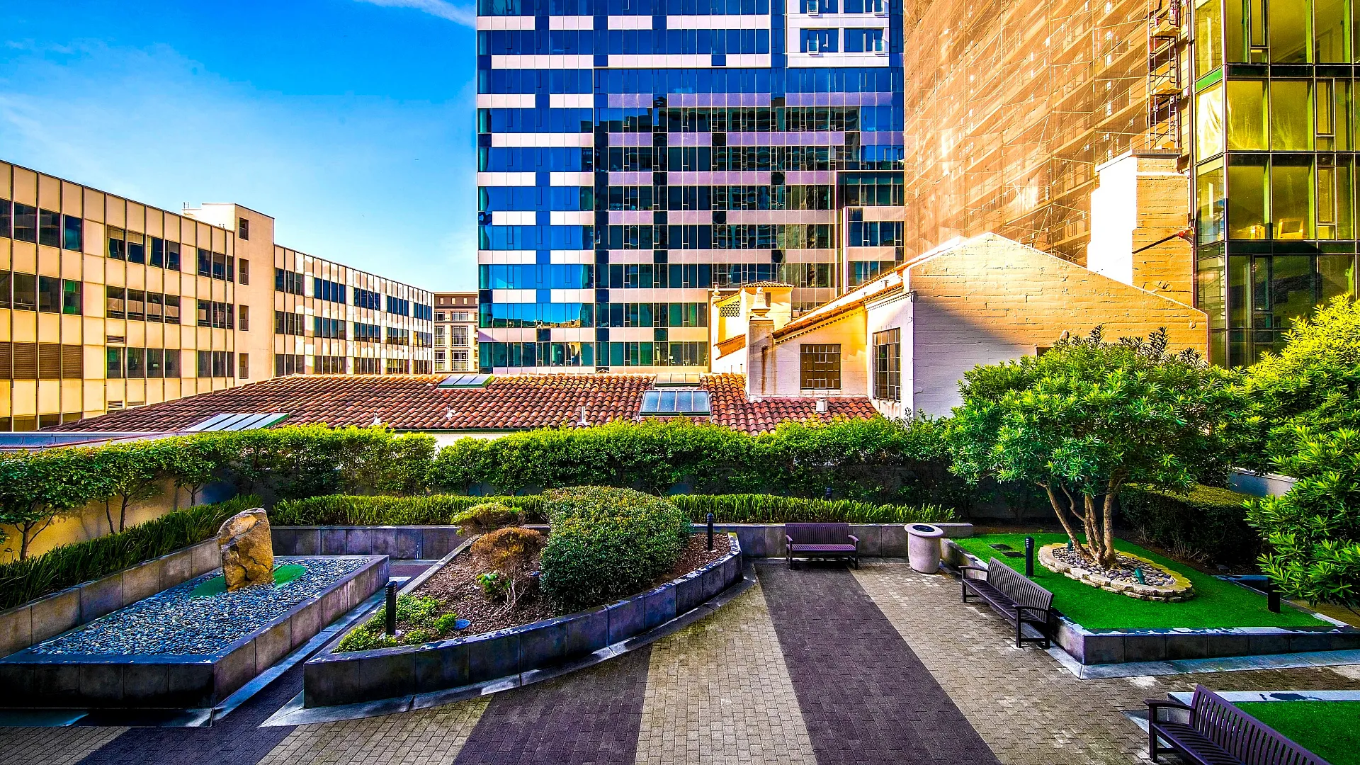 Vibrant urban courtyard showcasing modern architecture with lush greenery and stylish seating areas.