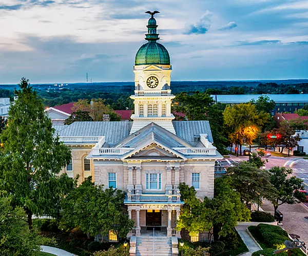 Aerial view of a historic building near Flats at General Time Apartments in Athens, GA, featuring a view of the water.
