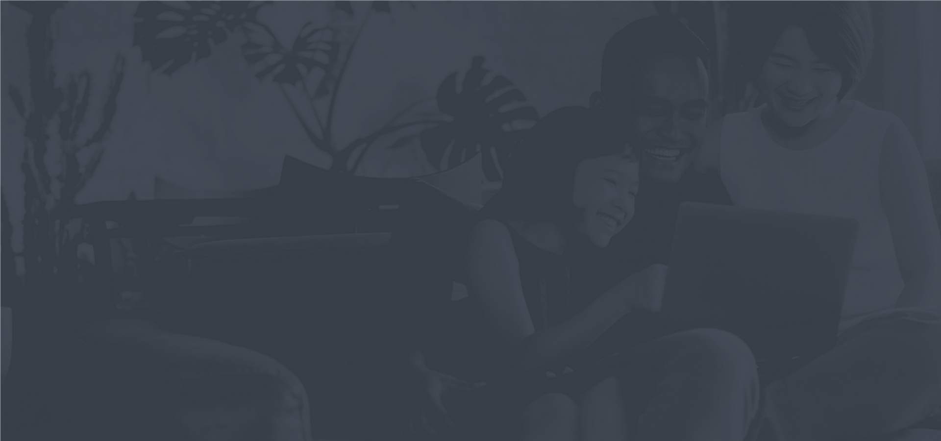 Joyful family enjoying quality time together on a cozy couch with a laptop, surrounded by lush indoor plants.