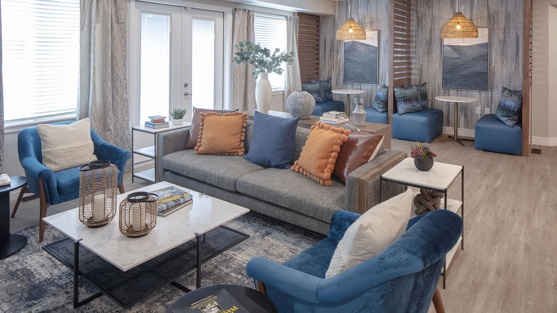 Inviting living room with stylish decor, featuring a cozy gray sofa, vibrant blue accents, and wicker pendant lighting, perfect for relaxation and entertaining.