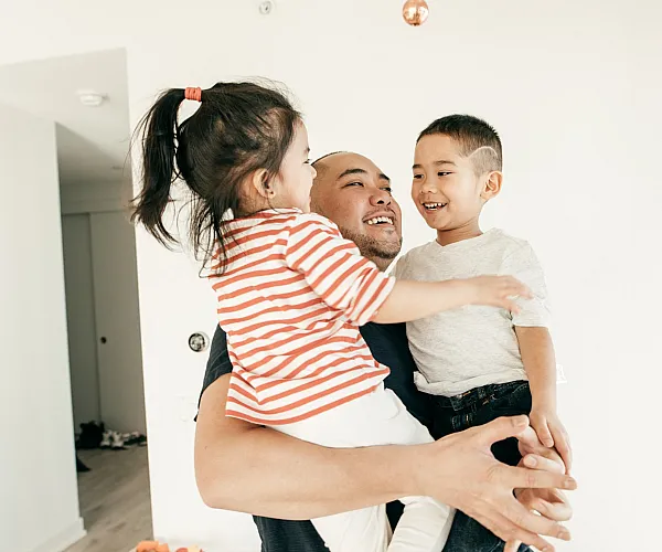 Heartwarming moment featuring a joyful family in a bright, modern apartment, showcasing a spacious and inviting interior.