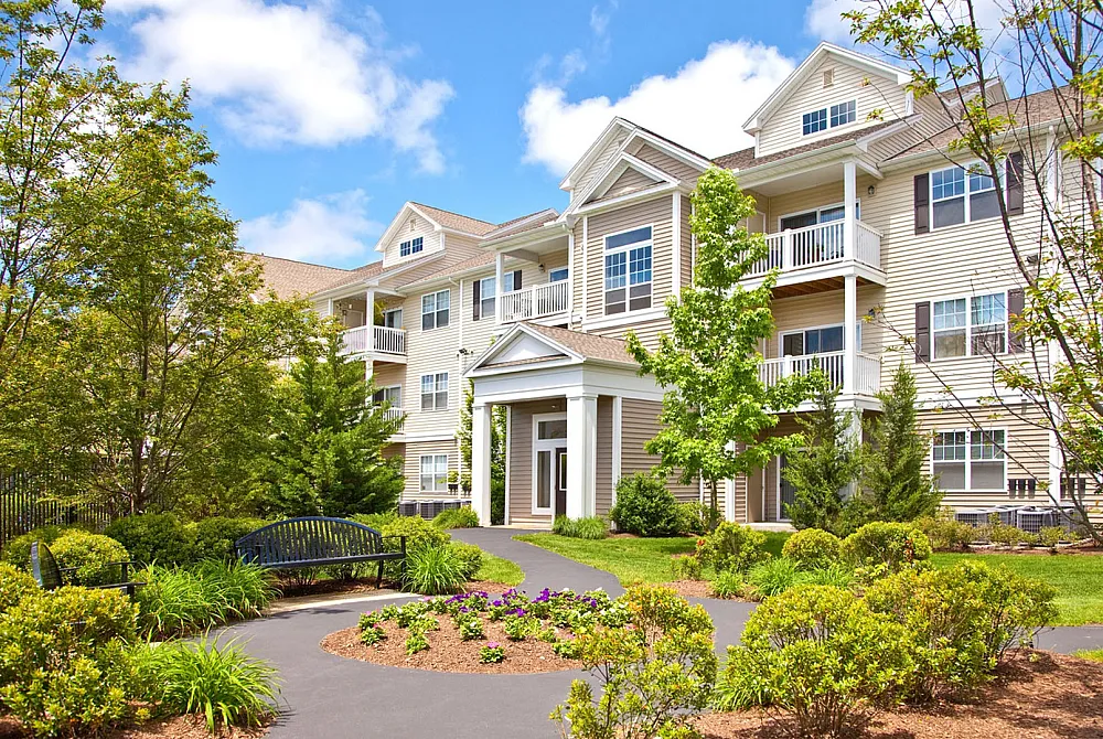 Charming apartment complex with elegant architecture surrounded by lush greenery and vibrant gardens.