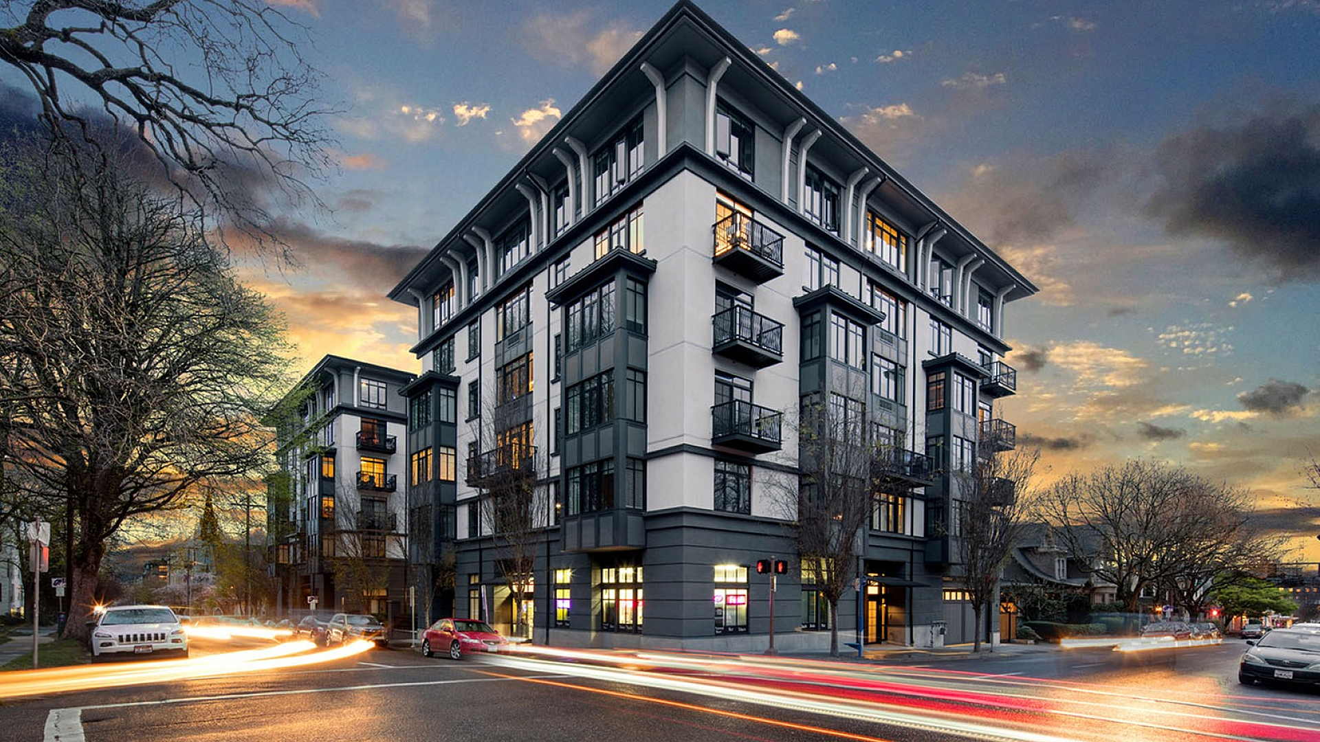 Modern luxury apartment building at dusk with elegant balconies and vibrant cityscape, perfectly blending urban convenience with serene living.