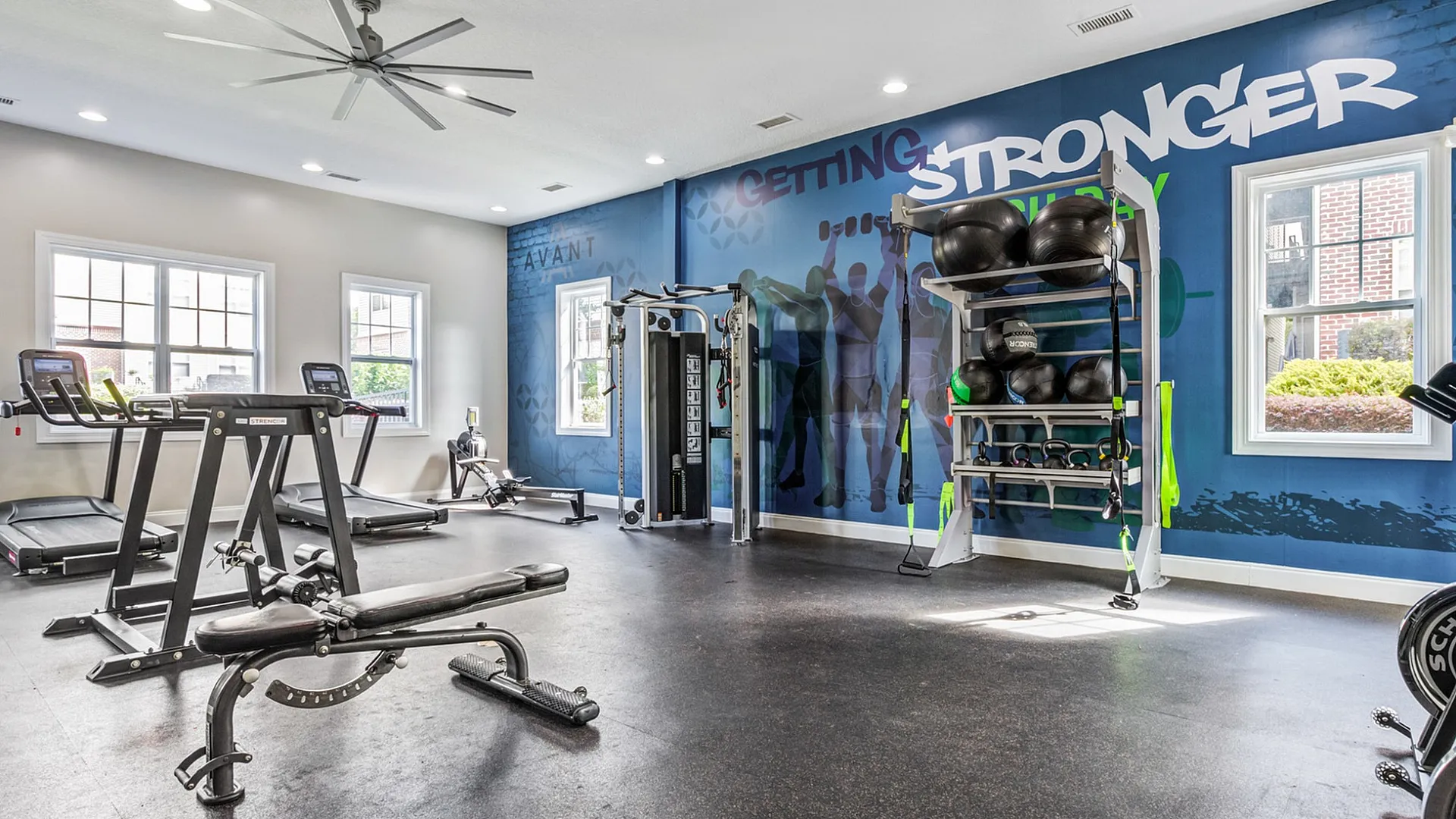 Modern fitness center with high-end treadmills, weight training equipment, and vibrant motivational wall art.