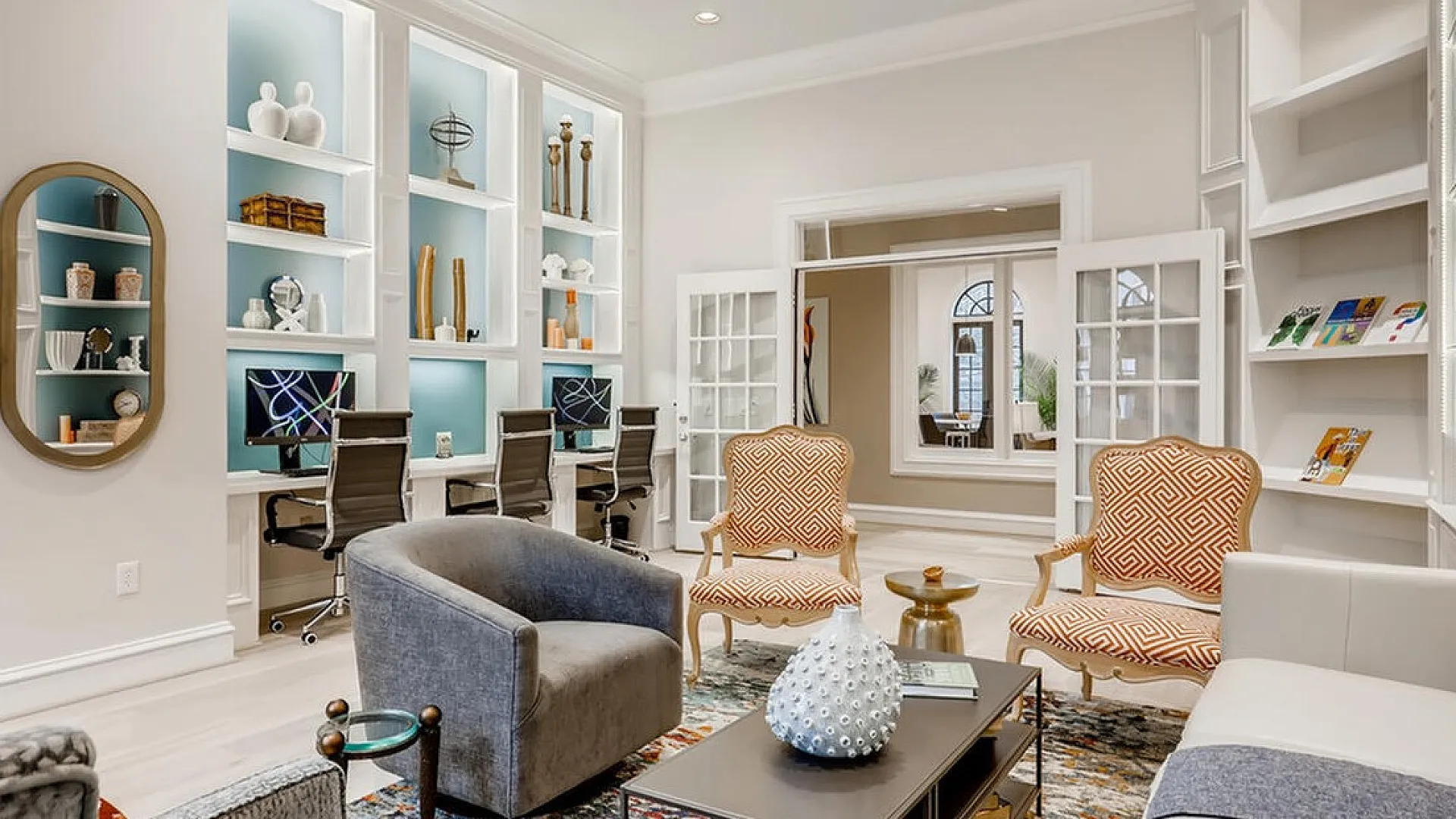 Elegant living space with chic decor, featuring cozy seating, stylish shelving with modern accents, and a sleek workspace.