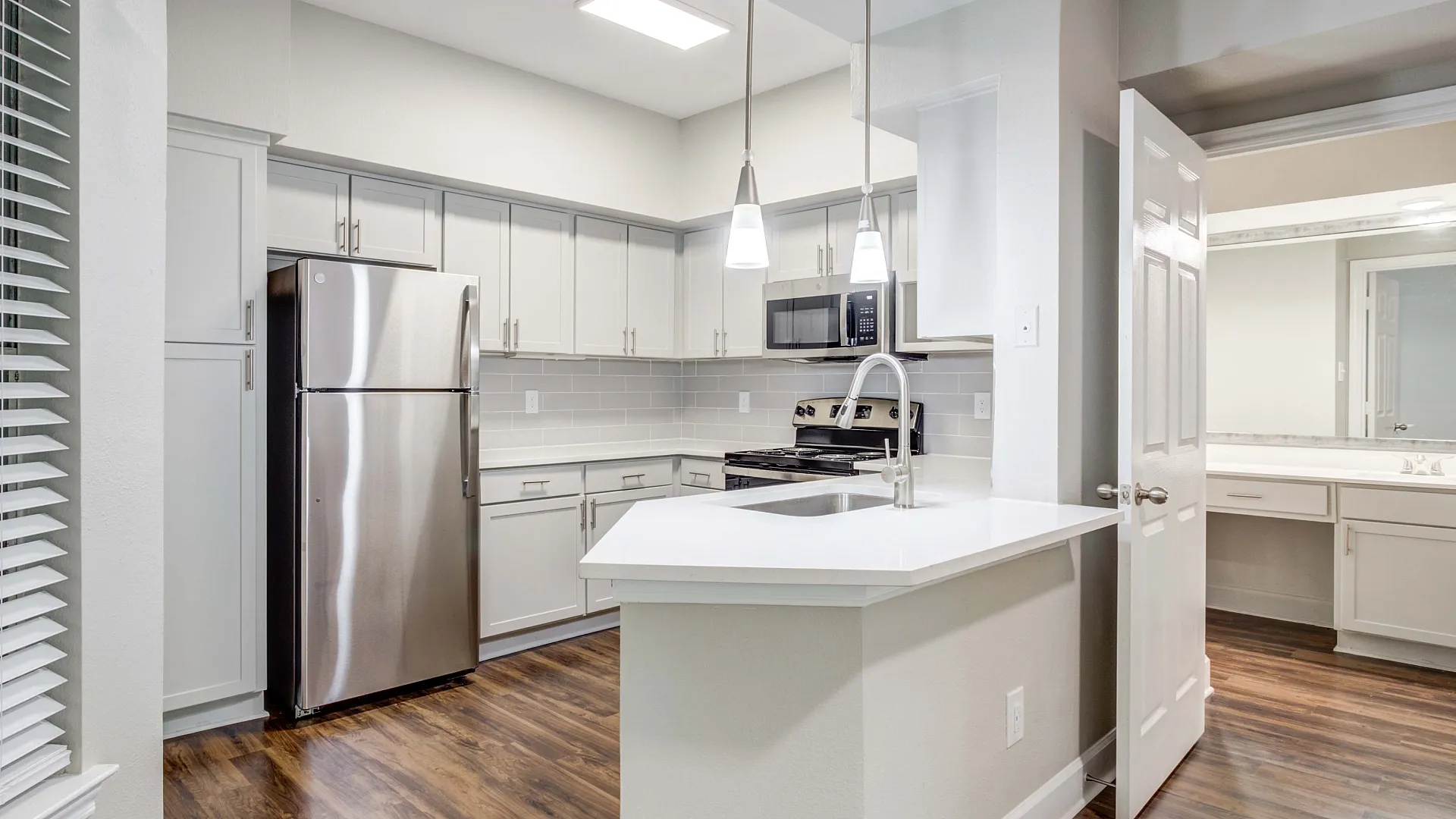 Modern kitchen with sleek stainless steel appliances, elegant cabinetry, and chic pendant lighting, perfect for culinary enthusiasts.