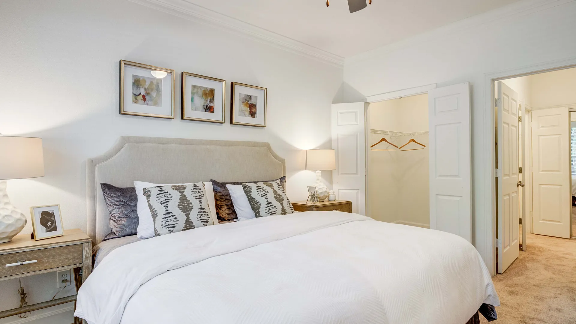 Elegant bedroom featuring a plush king-sized bed with stylish cushions and a spacious walk-in closet.