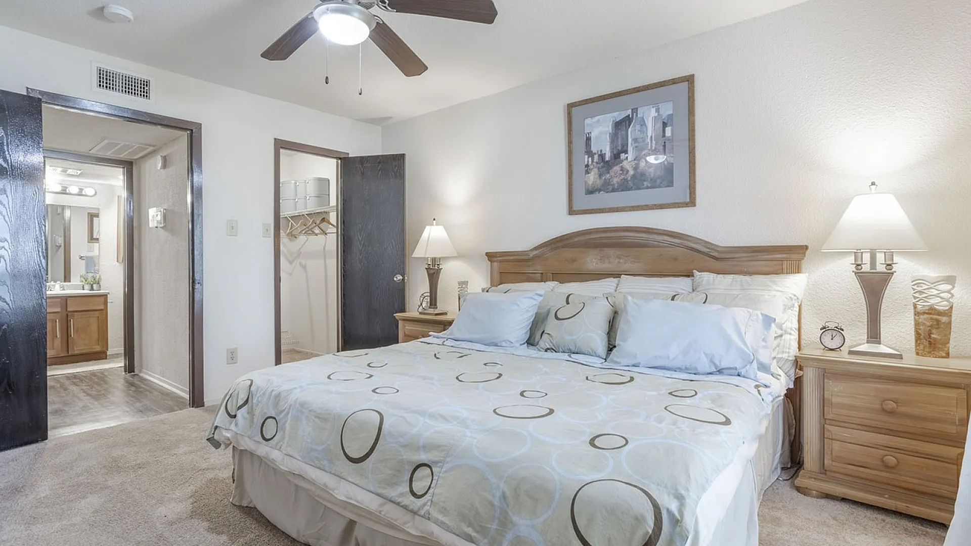Inviting bedroom with cozy double bed, modern ceiling fan, and convenient en-suite bathroom access, perfect for relaxation and comfort.