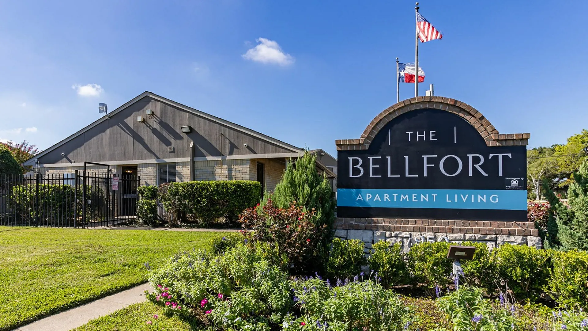 Vibrant exterior view of The Bellfort Apartment Living with lush gardens and welcoming entrance.