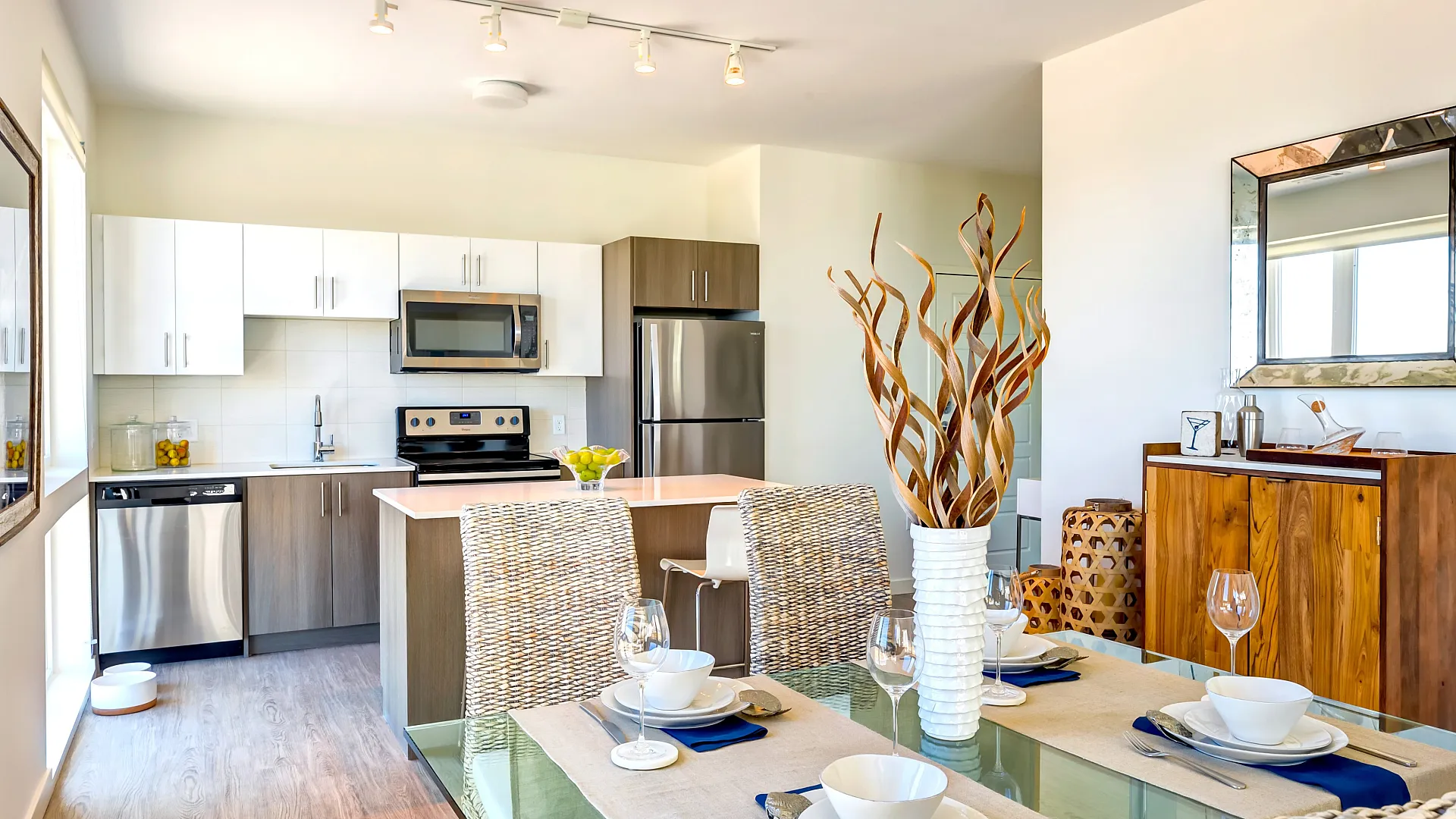 Bright and modern kitchen and dining area with sleek appliances, elegant dining setup, and stylish decor.