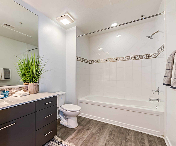 Luxurious modern bathroom with elegant double sink vanity, large mirror, stylish tile accents, and inviting bathtub.