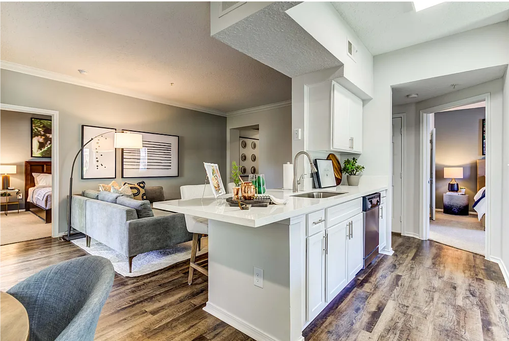 Chic open-plan living area with sleek kitchen, cozy seating, and stylish decor leading to modern bedrooms.