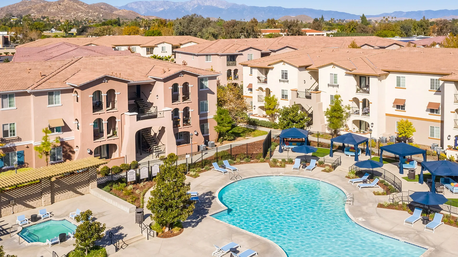 Luxurious apartment complex with refreshing swimming pool, stylish lounge areas, and stunning mountain views.