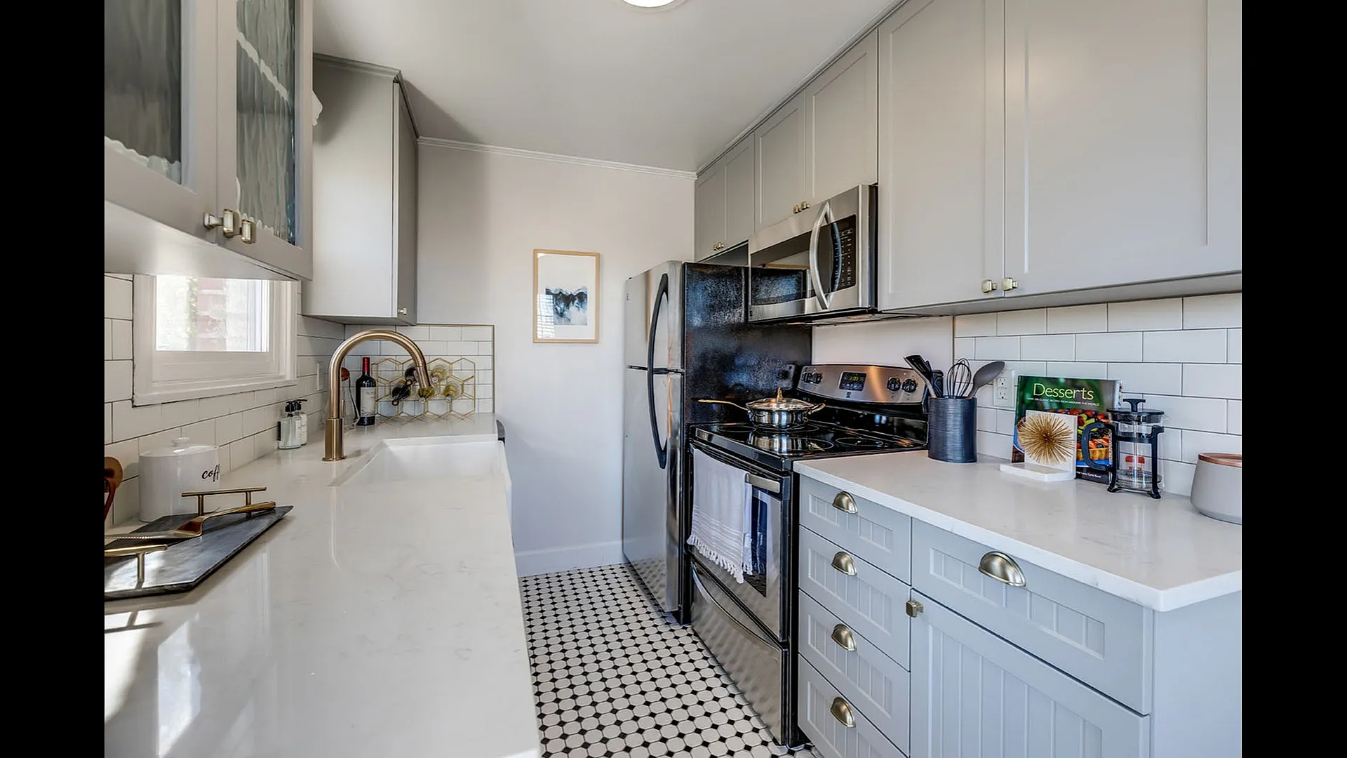 Bright kitchen with large windows, elegant cabinetry, and a modern sink offering scenic views.