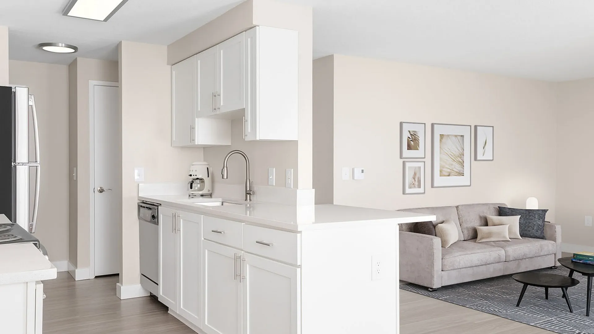 Bright open-plan living area with modern kitchen, sleek white cabinets, and inviting cozy living room with stylish decor.