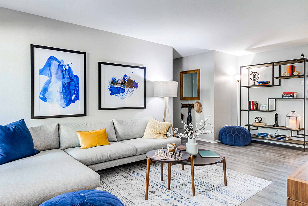 Modern communal lounge with vibrant wall art, cozy fireplace, and sleek wooden furniture, offering a relaxed and stylish atmosphere.